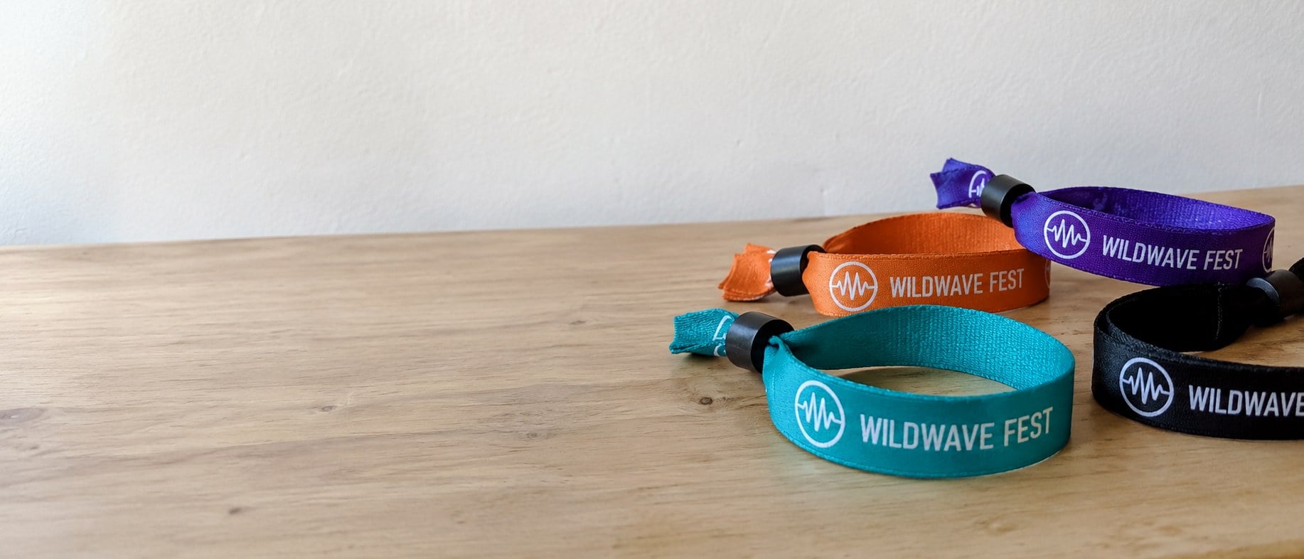 Custom woven cloth event wristbands fanned out on a table